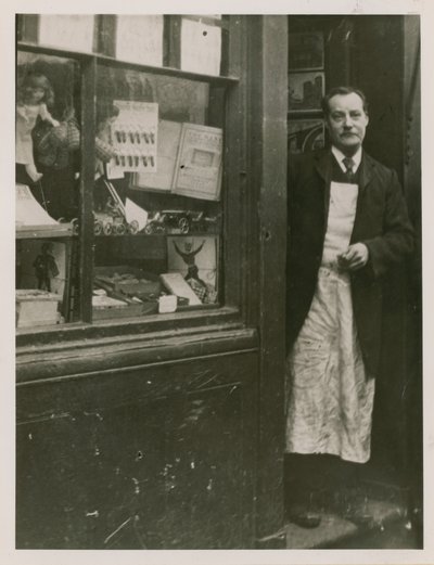 Een winkelier die in de deuropening van zijn winkel staat door English Photographer